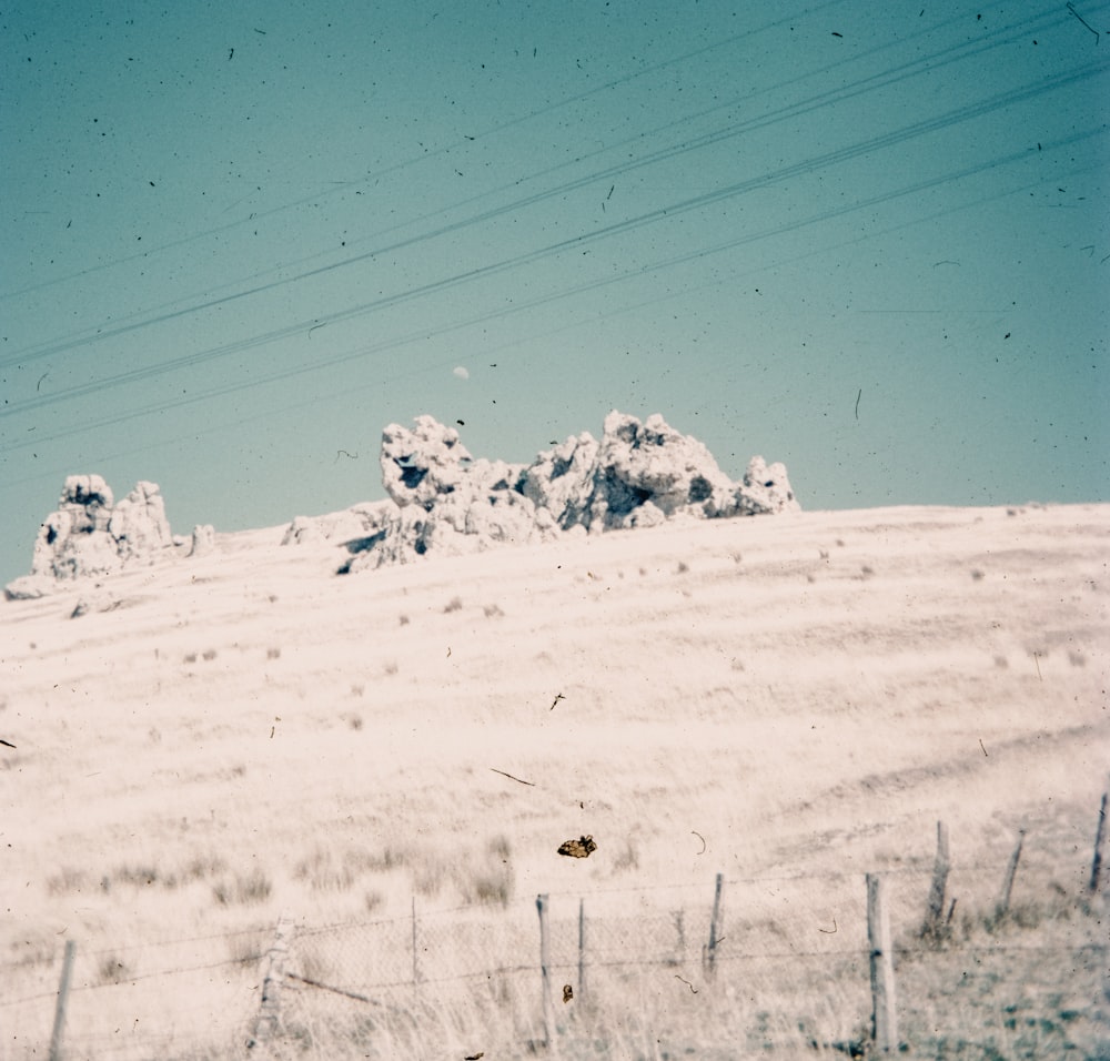 a snow covered hill with power lines in the background