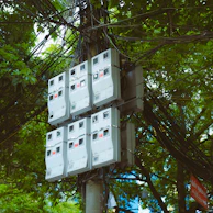 a bunch of electrical boxes sitting on top of a pole