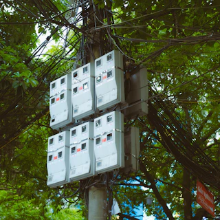 a bunch of electrical boxes sitting on top of a pole