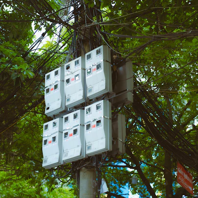 a bunch of electrical boxes sitting on top of a pole