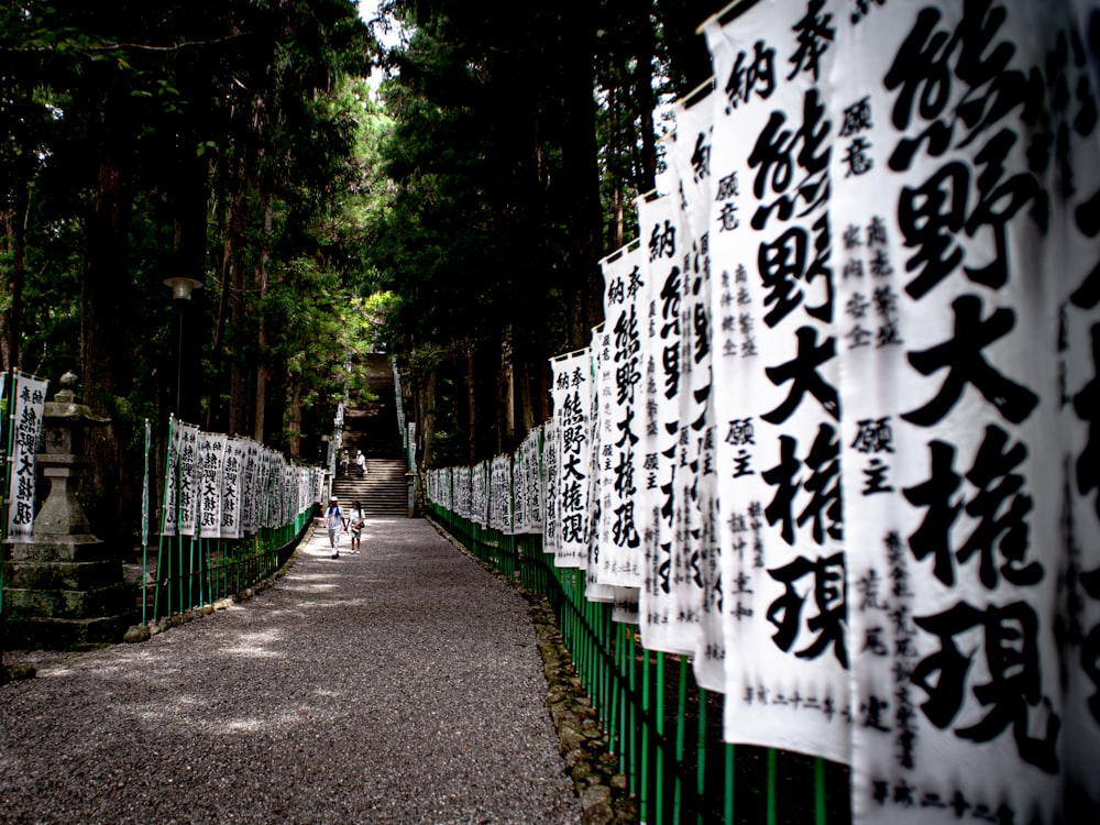 a walkway lined with lots of white and black signs