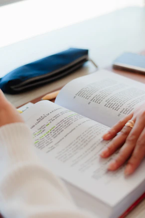 a person is reading a book on a table