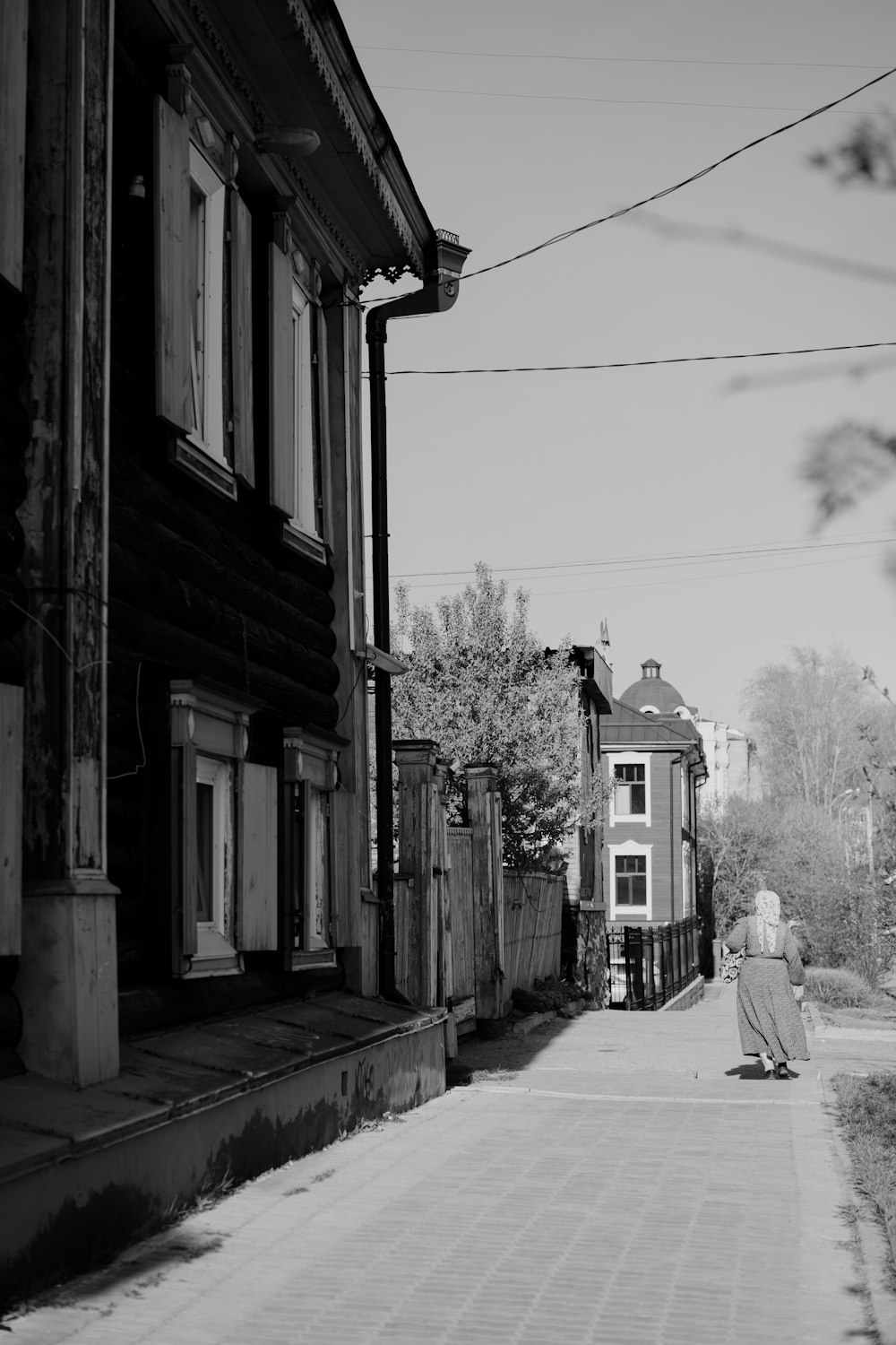 a black and white photo of a woman walking down a street