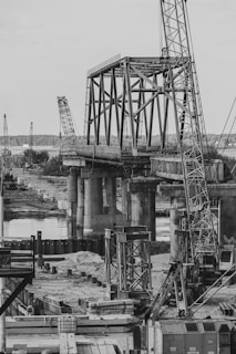 a black and white photo of a train bridge