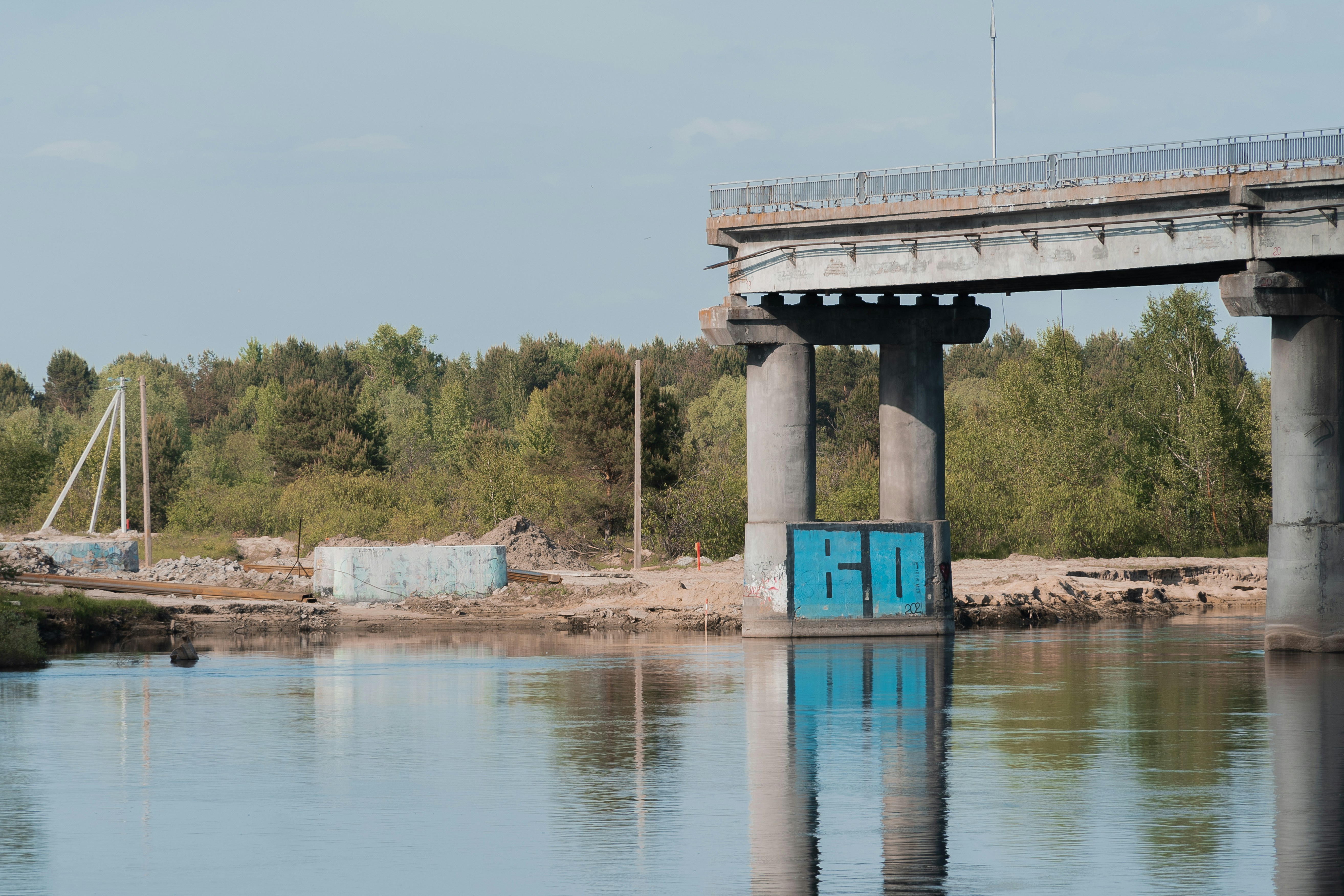 a bridge over a body of water with trees in the background