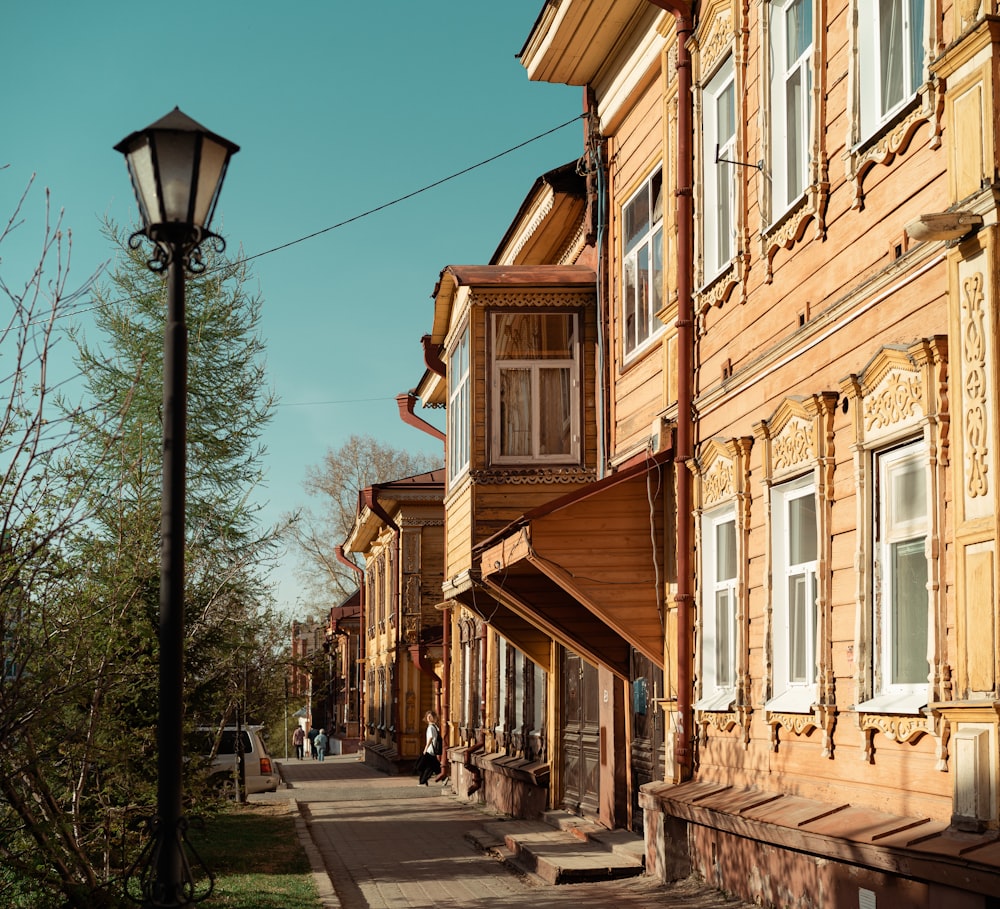 a row of wooden buildings next to a street light