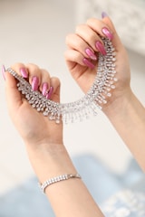 a woman's hand holding a necklace and bracelet