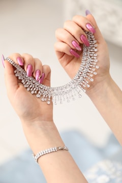 a woman's hand holding a necklace and bracelet