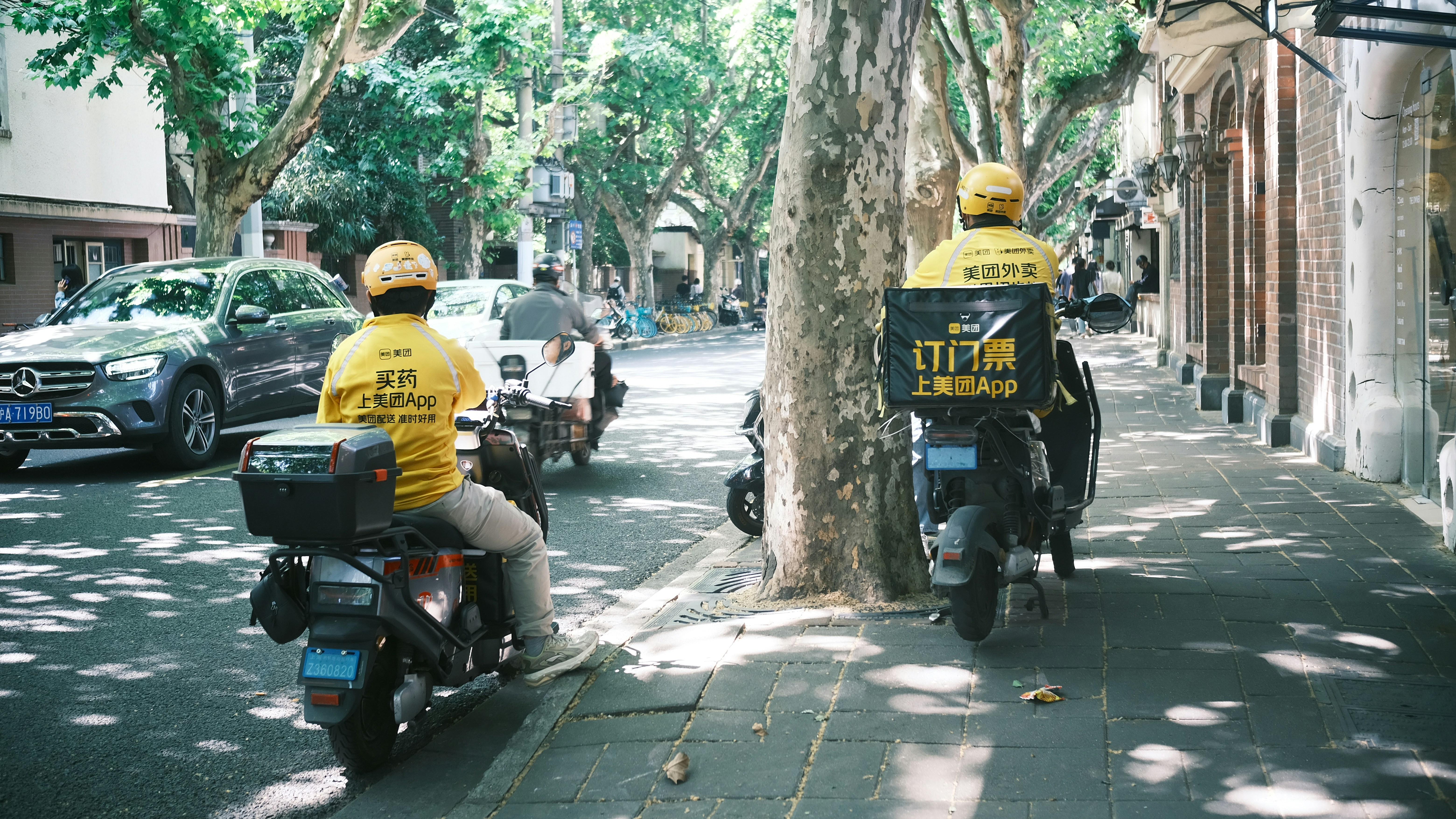 a couple of people riding motorcycles down a street