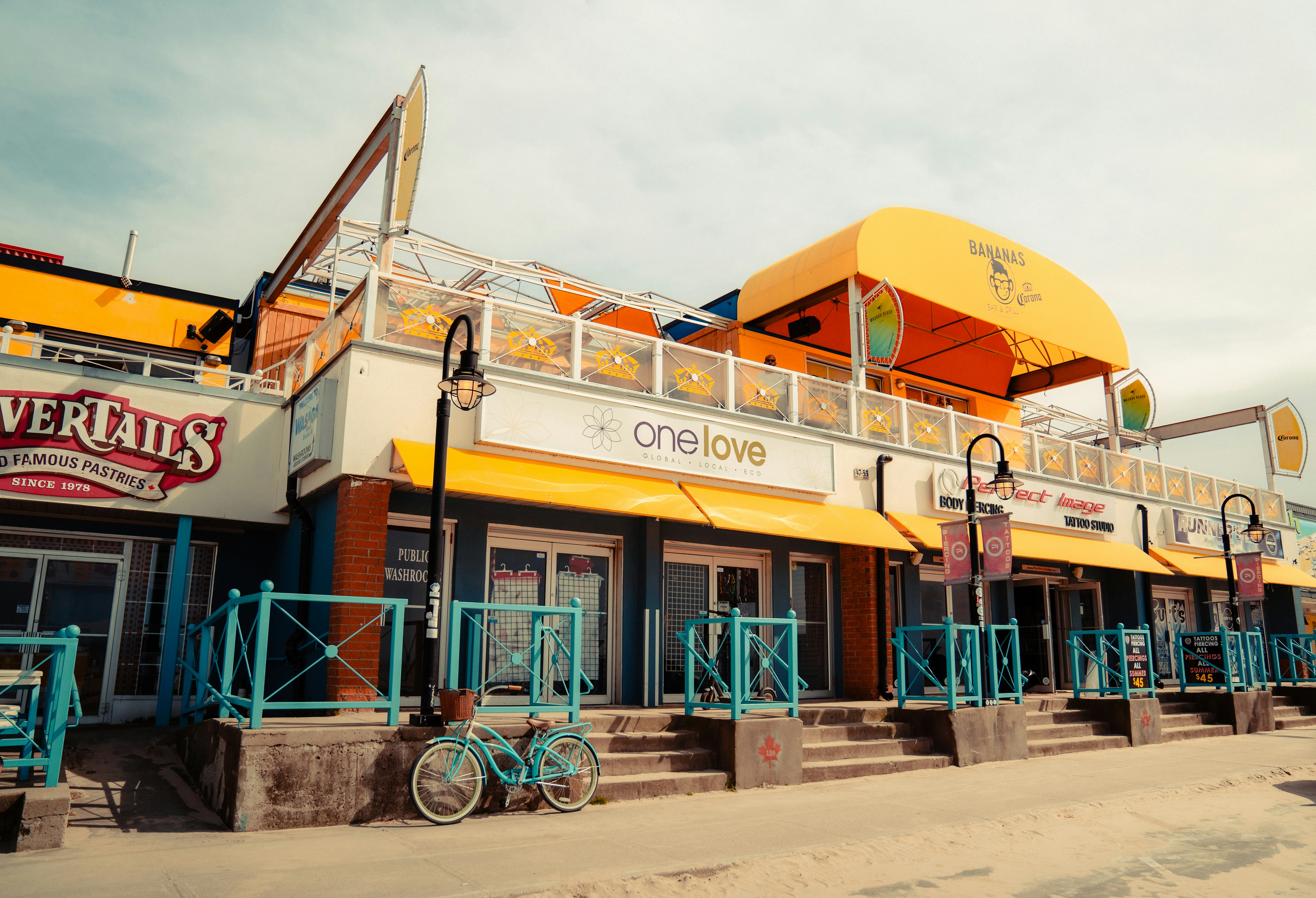 a yellow and blue restaurant with a bike parked in front of it