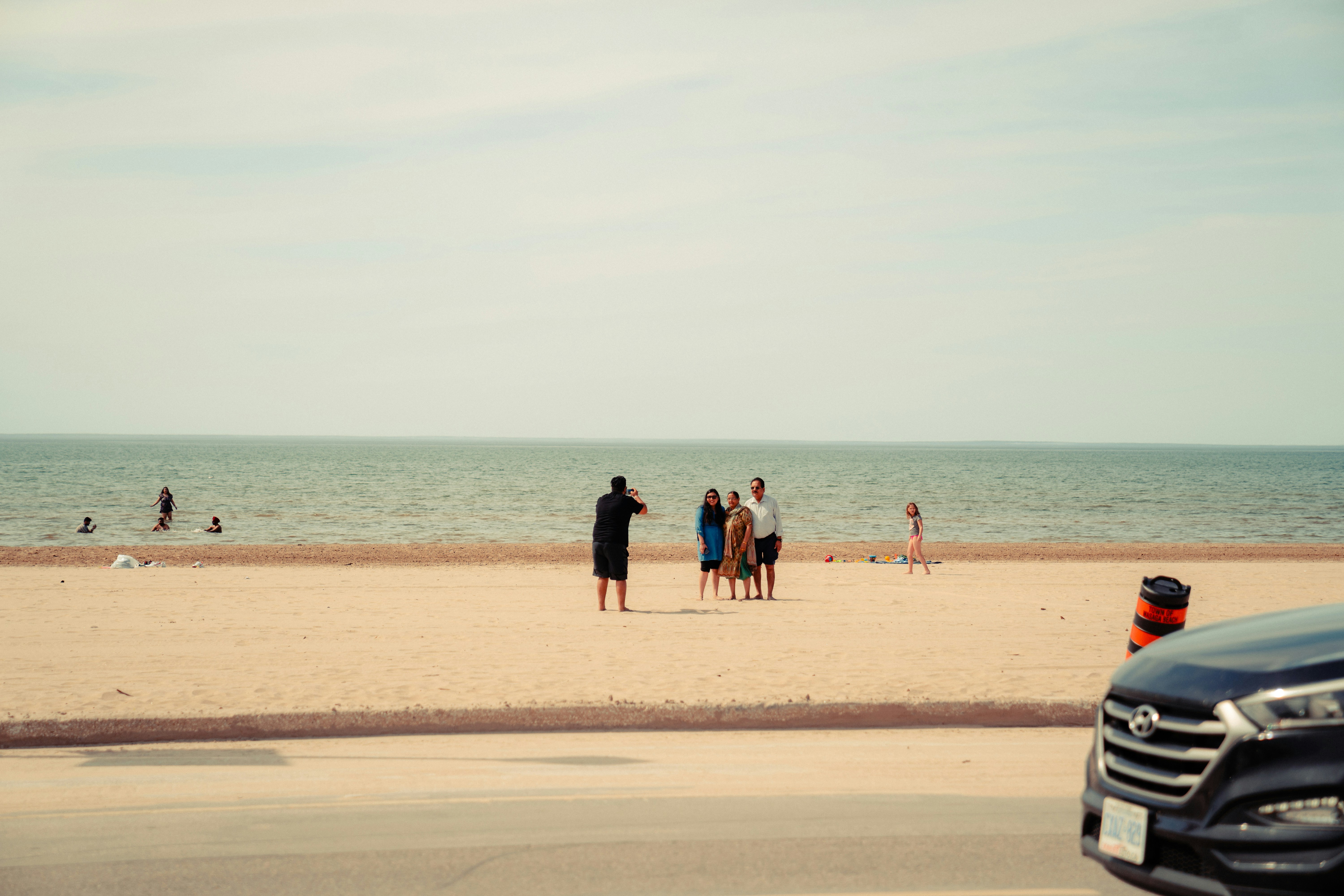 a group of people standing on top of a sandy beach