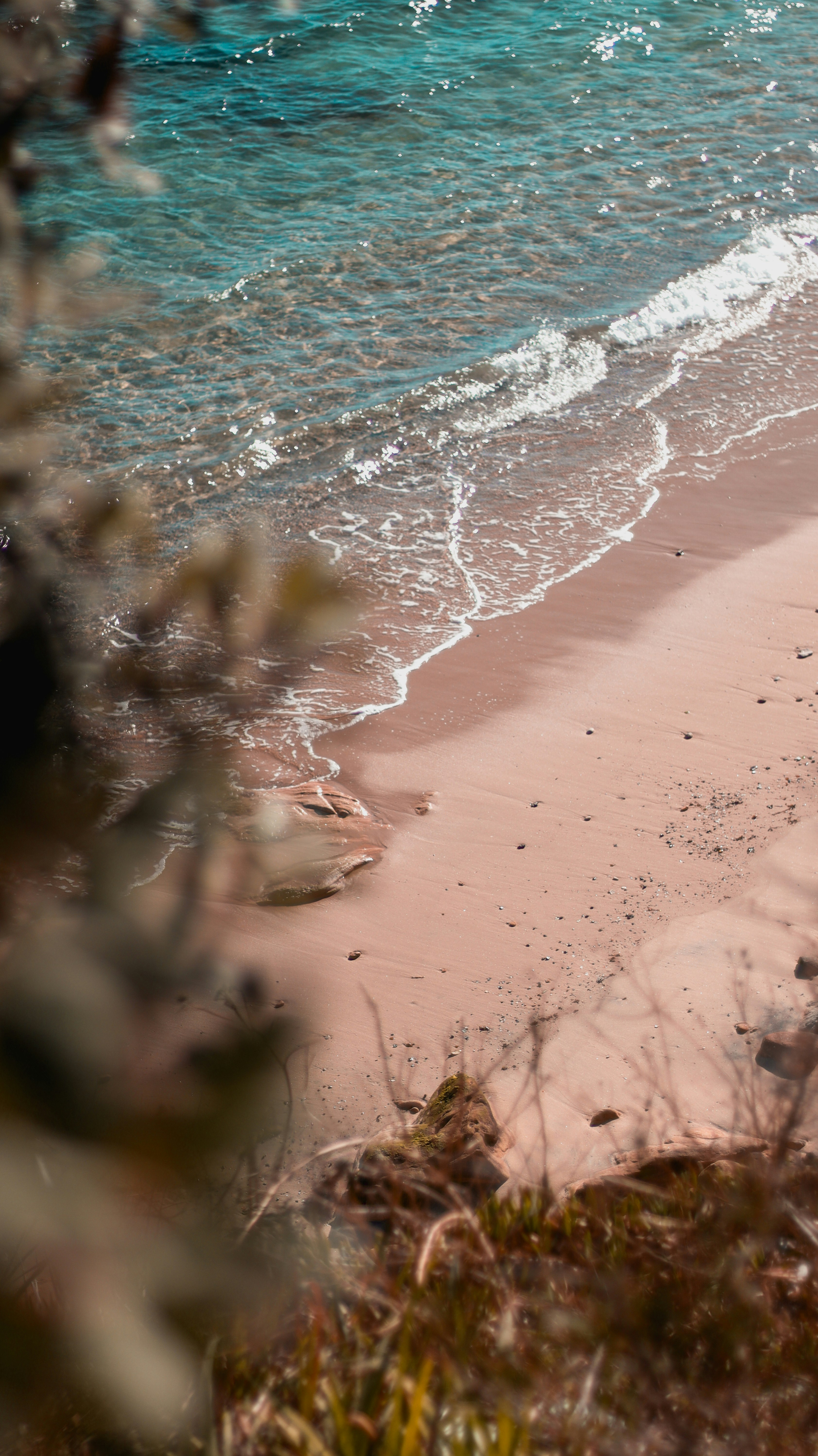 a sandy beach with waves coming in to shore