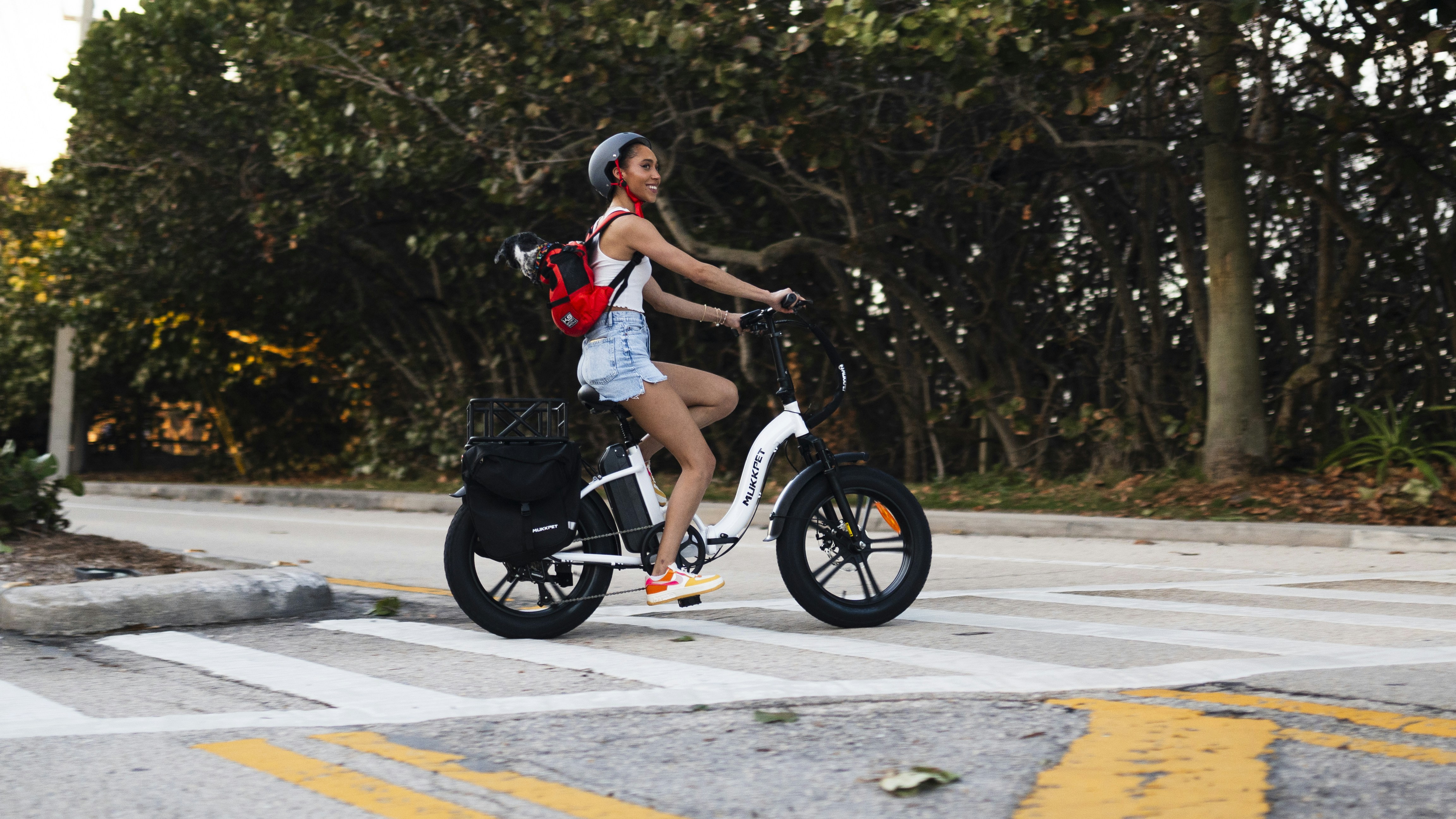 a woman riding a scooter across a cross walk