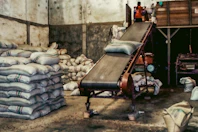 a conveyor belt in a warehouse filled with bags