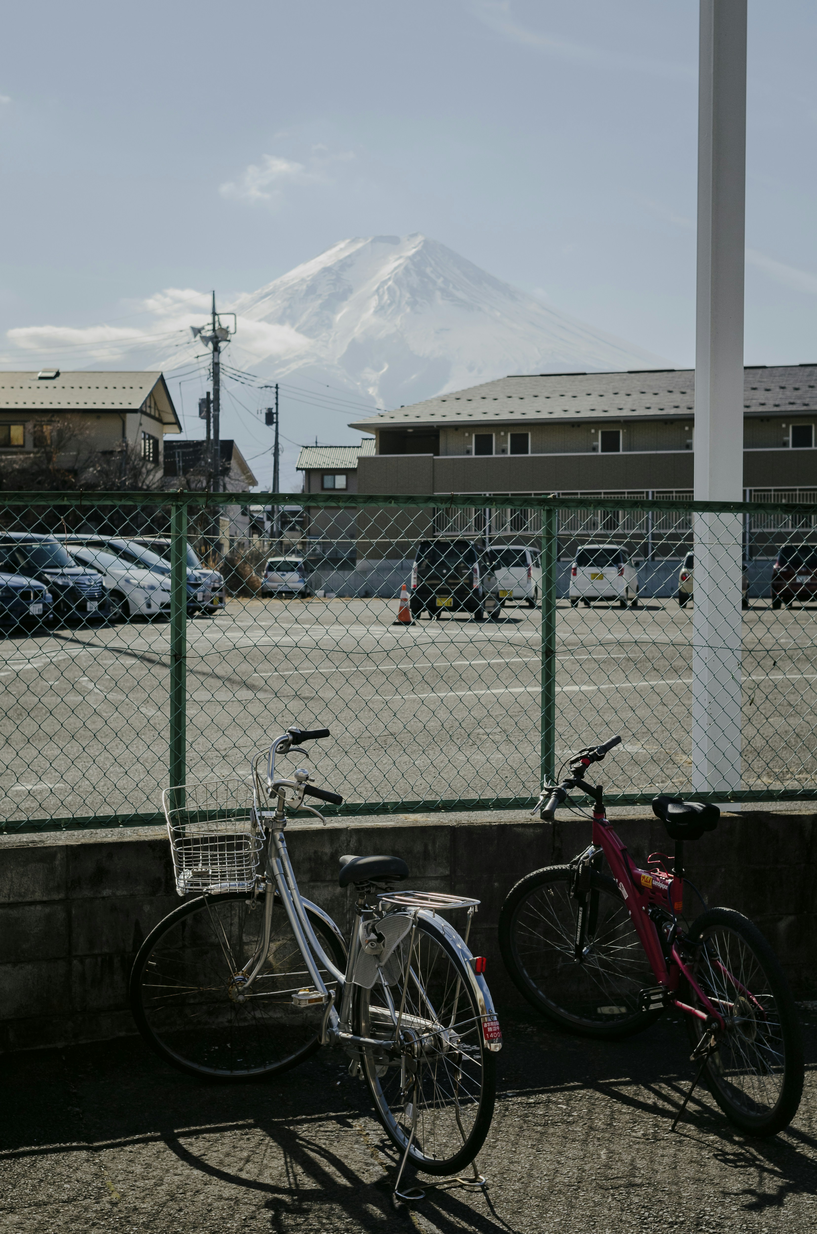 two bikes parked next to each other near a fence