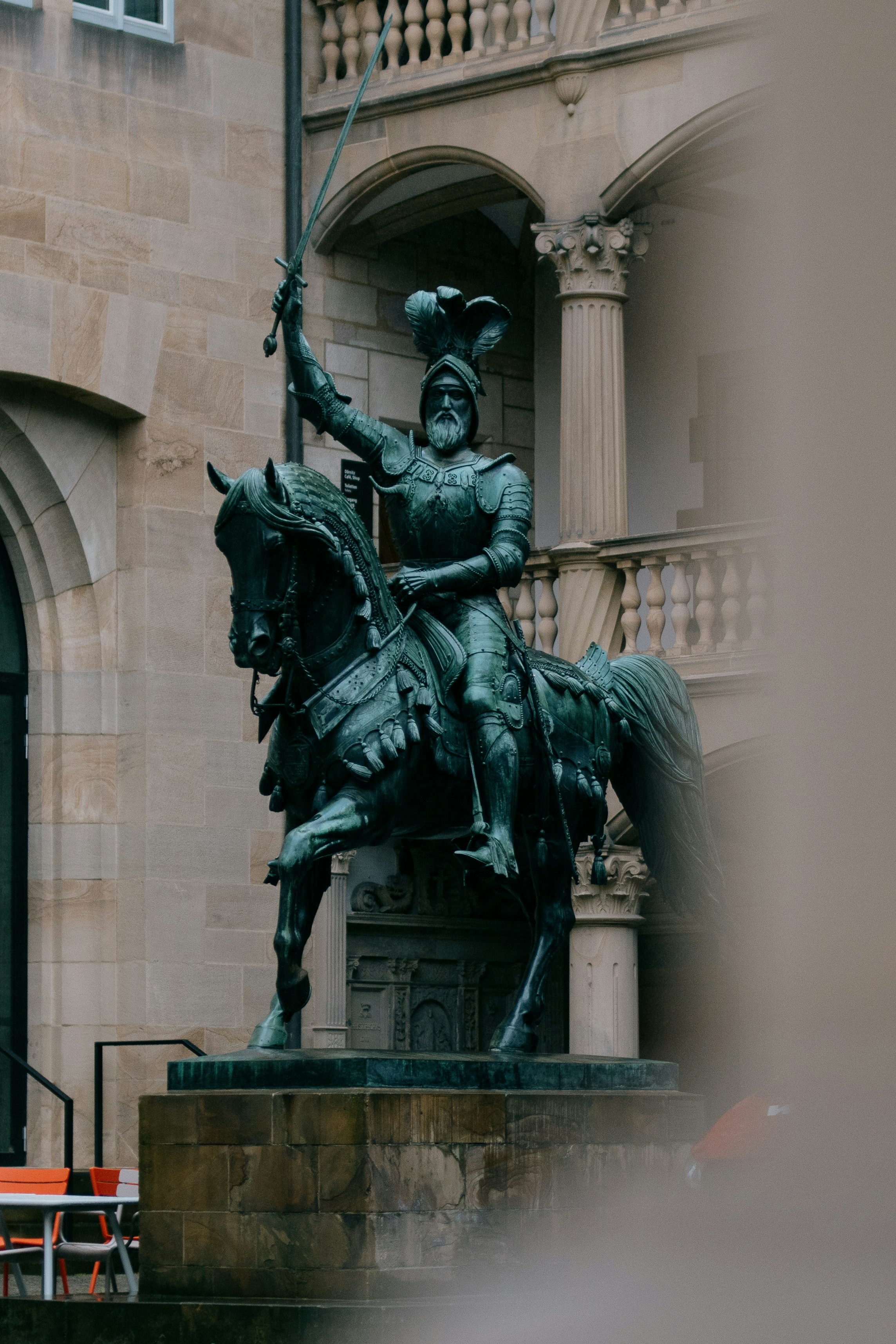 a statue of a man on a horse in front of a building