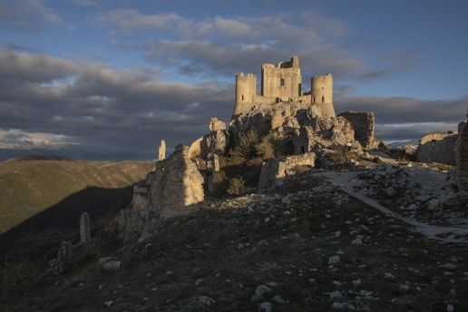 a castle sitting on top of a hill under a cloudy sky