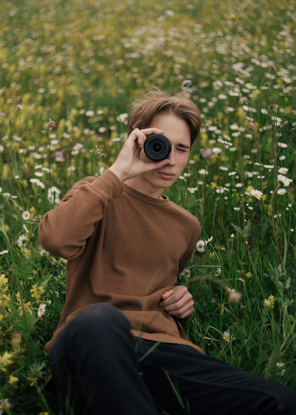 a man sitting in a field with a camera