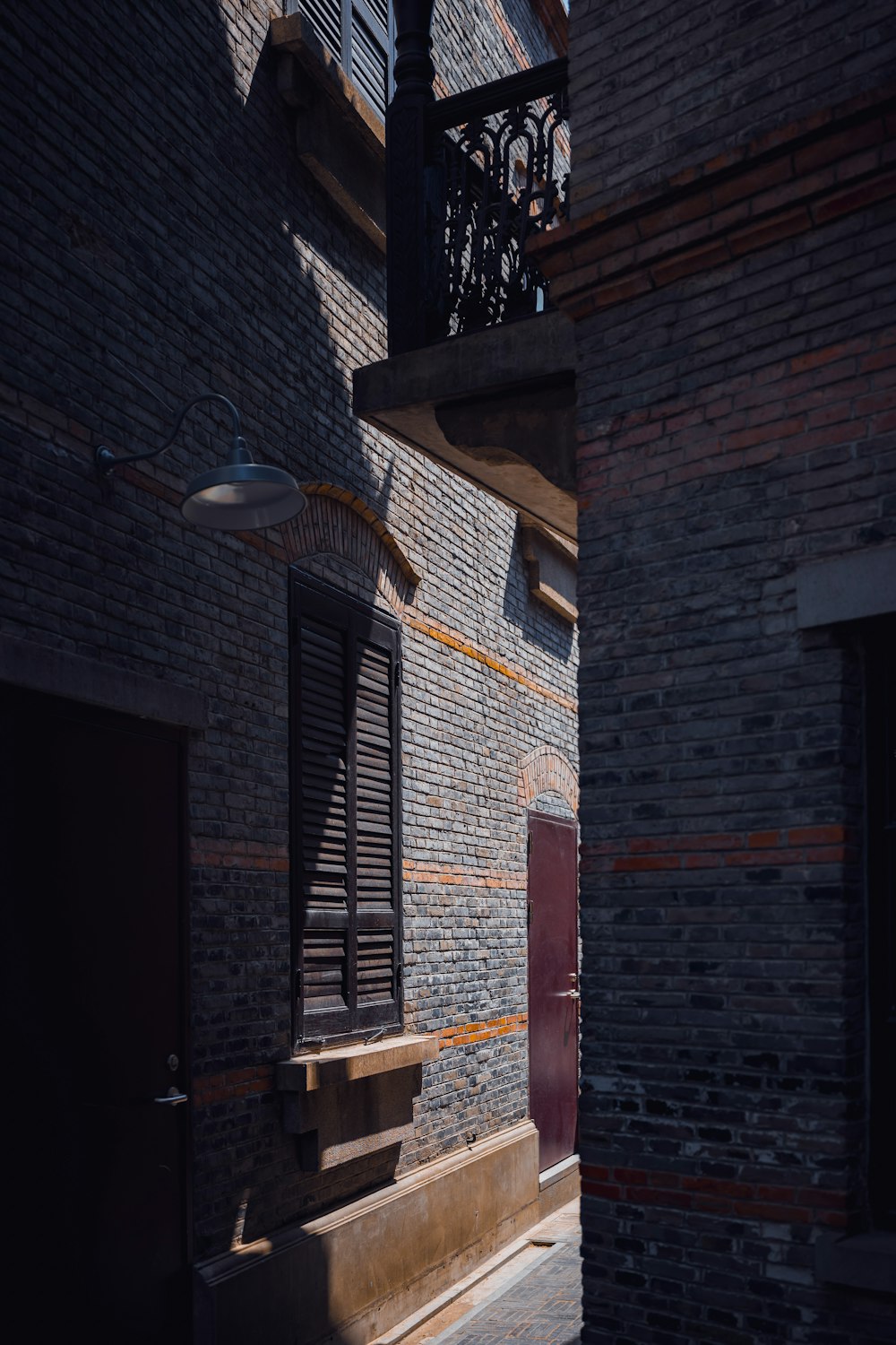an alley way with a brick building and a red door