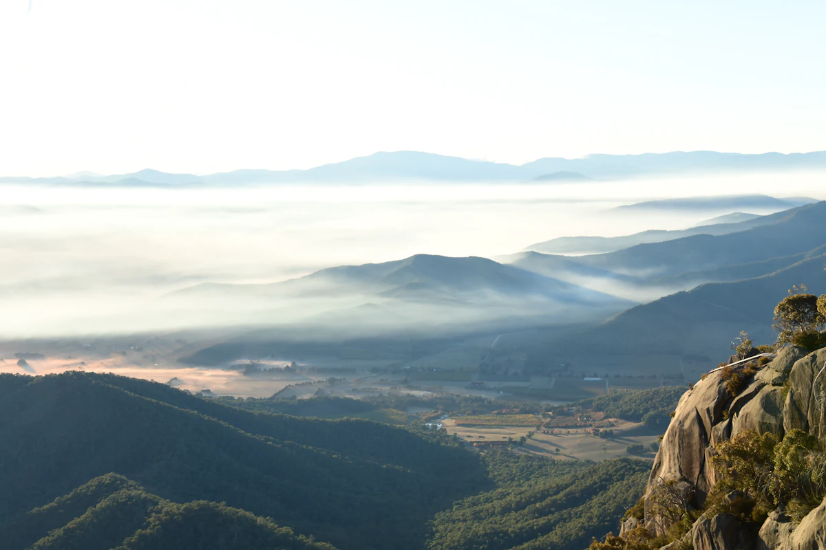 Morning fog filling the valleys below Mount Buffalo, with granite in the foreground