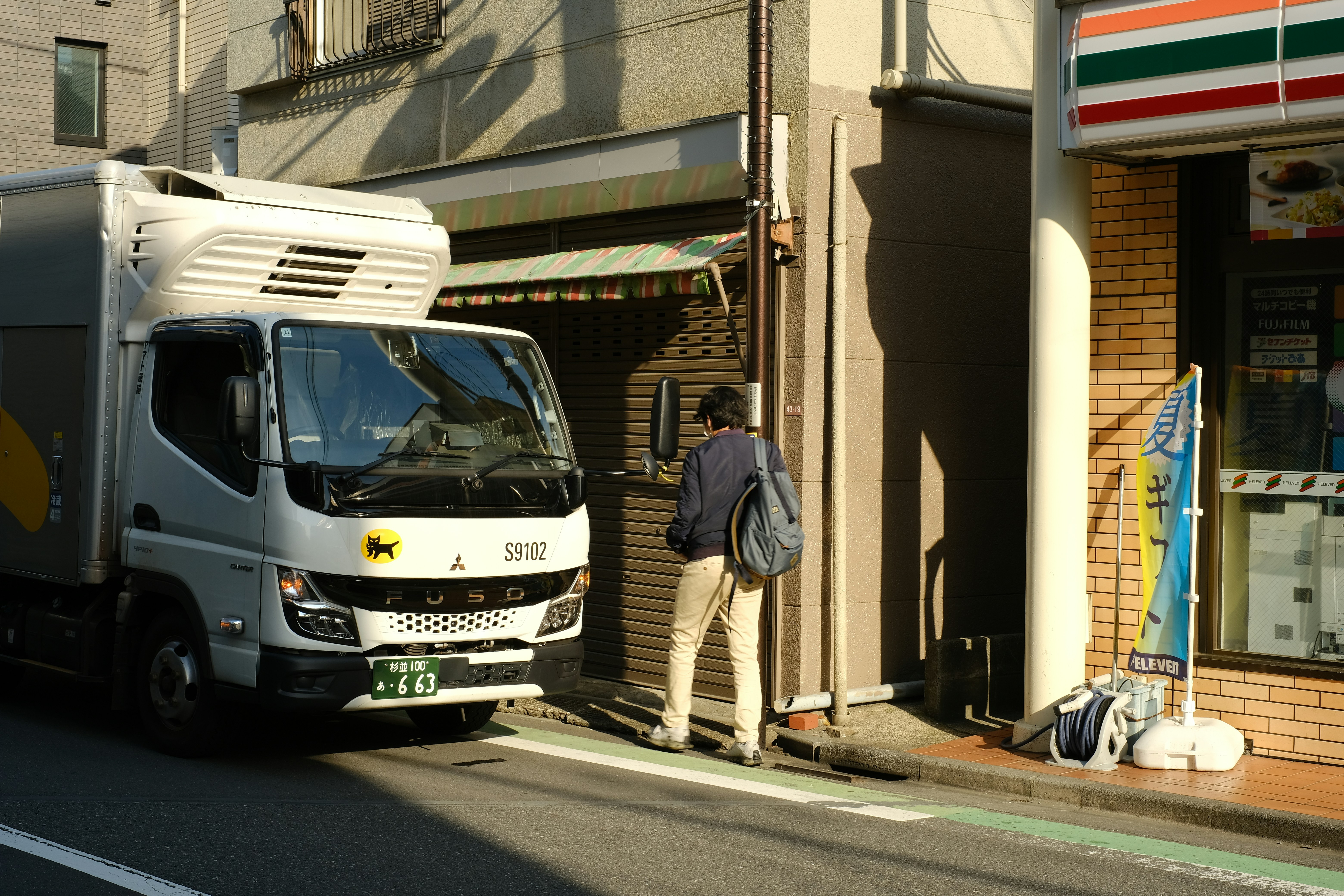 a man standing next to a truck on the side of a road