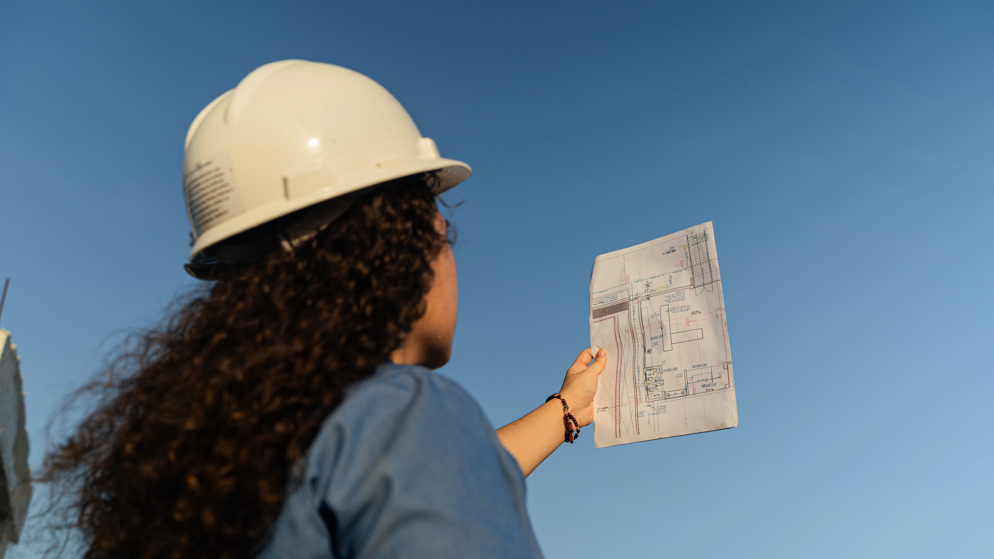 Femme en casque de chantier consultant un plan