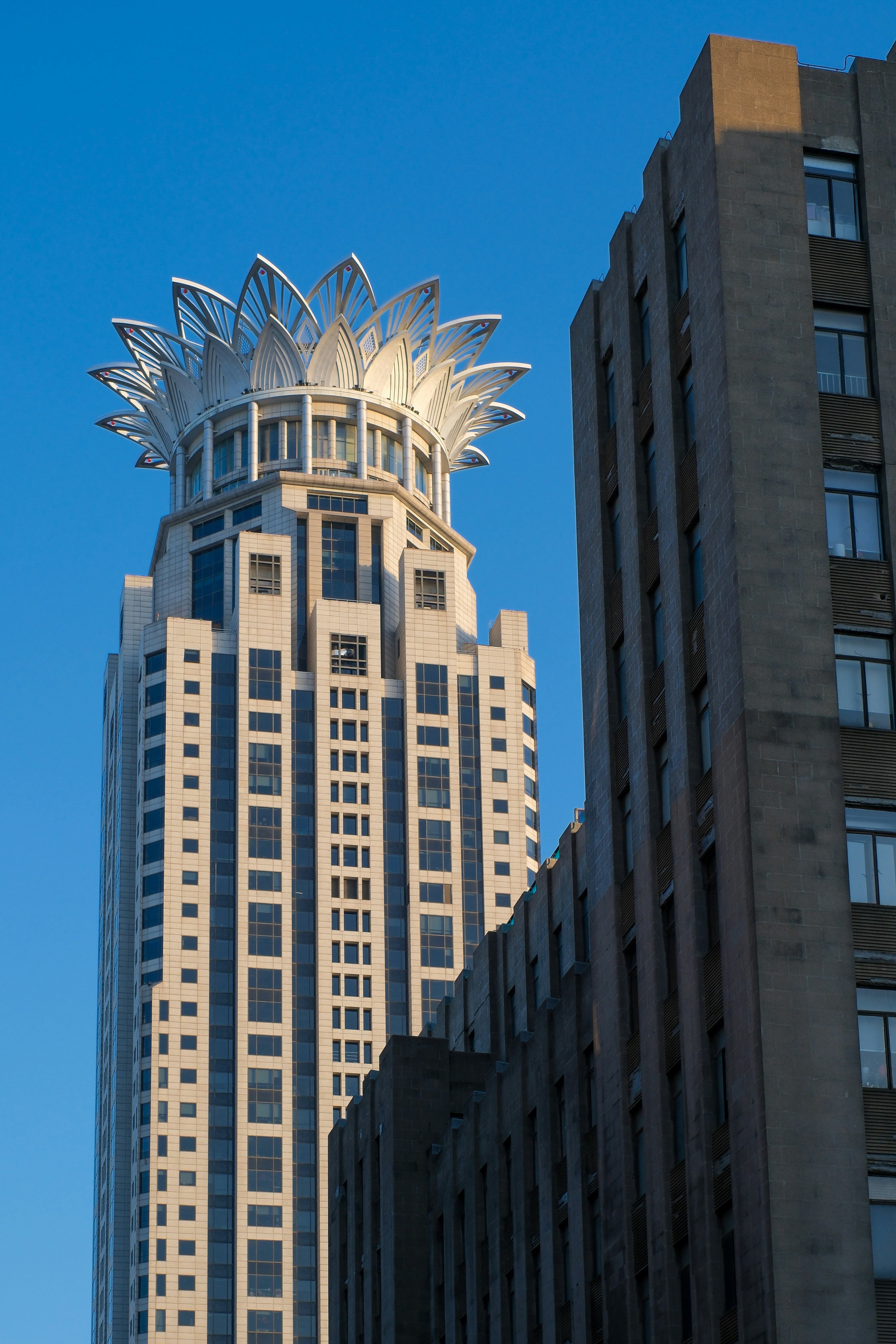 A tall building with a large flower on top of it photo – Free City ...