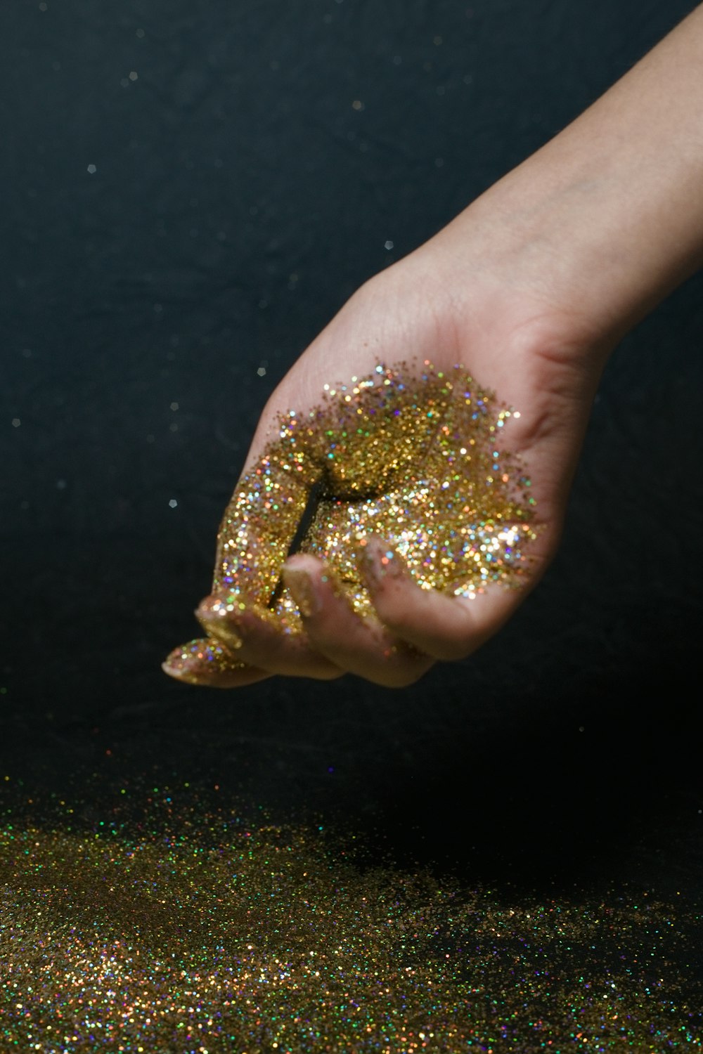 a person's hand holding a handful of glitter