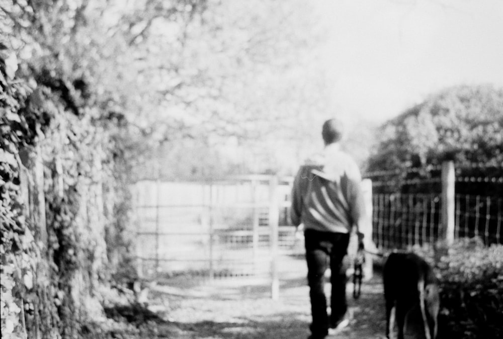 a man walking a dog down a path
