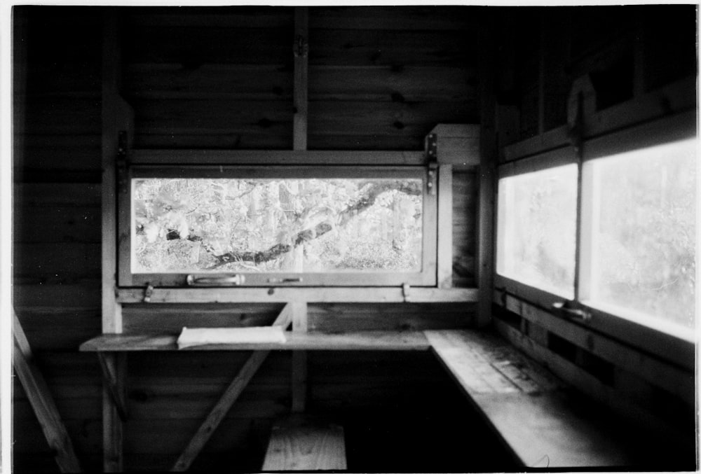 a black and white photo of a bench in a room