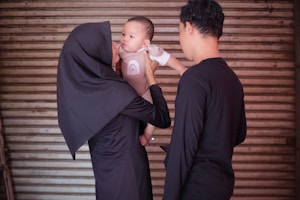 a man holding a baby in a nun costume