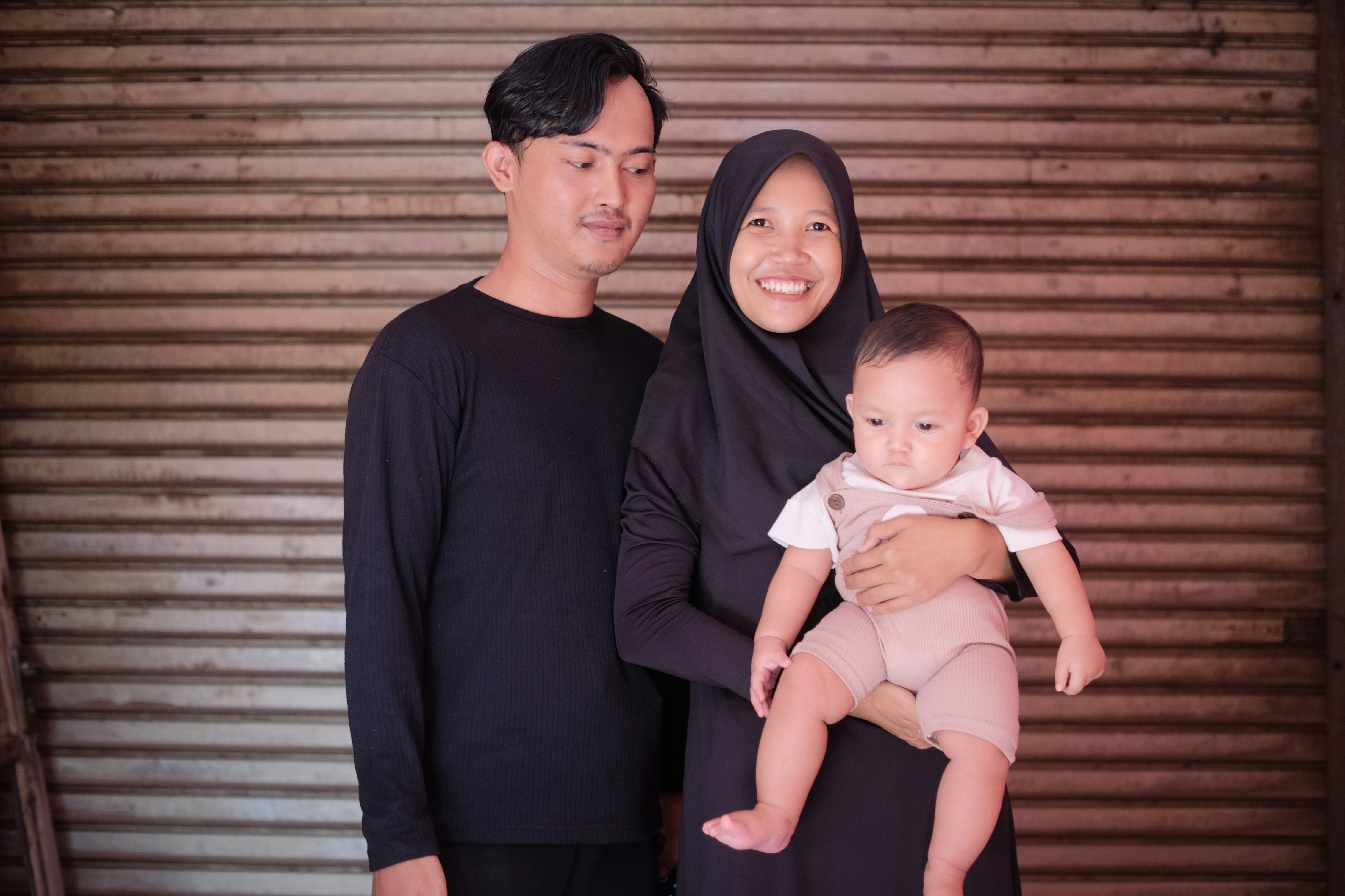 A man and woman holding their baby in a minimalist family portrait