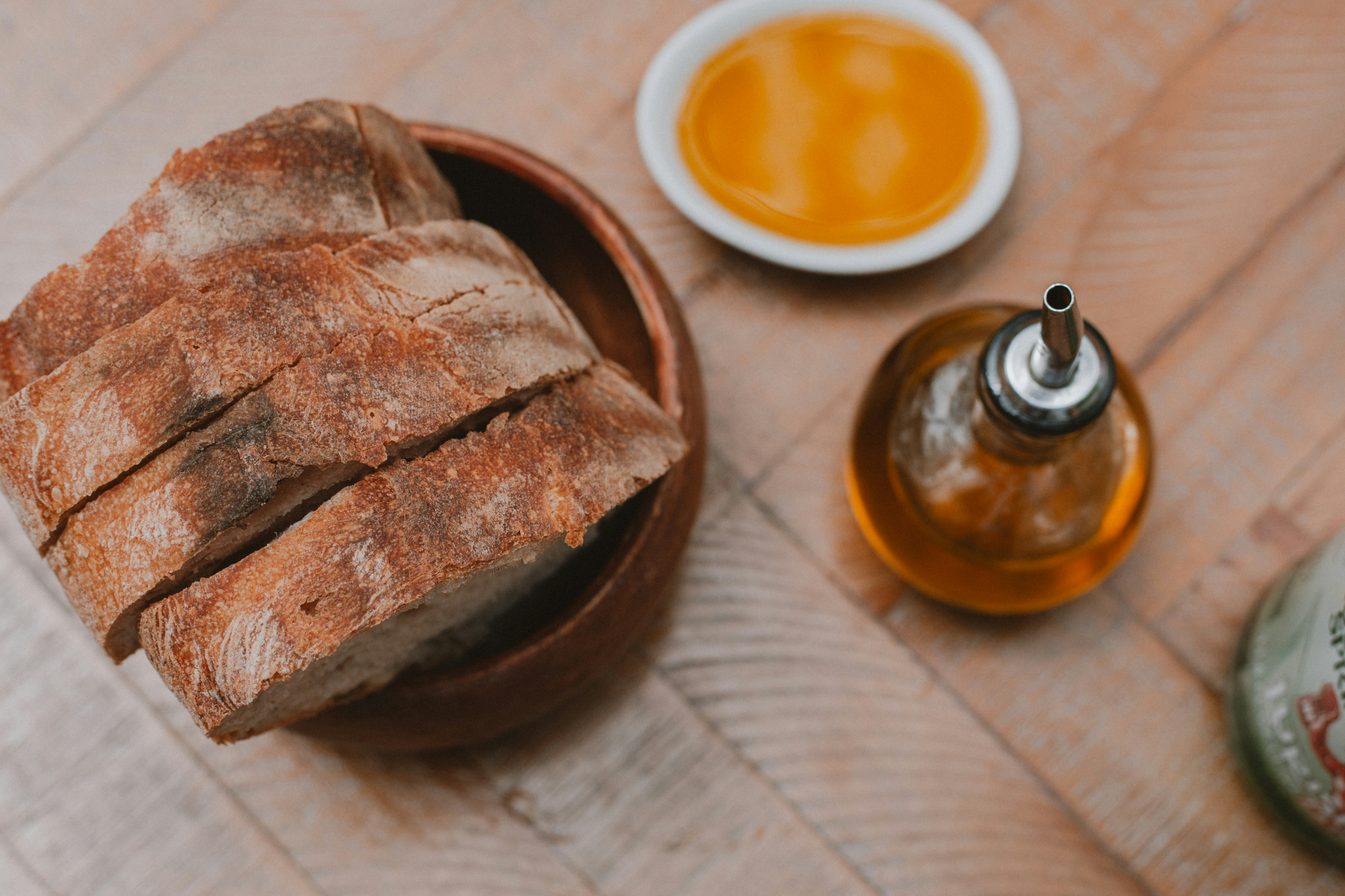 a loaf of bread sitting on top of a wooden table next to a bottle of