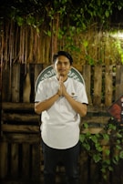 a man standing in front of a wooden fence