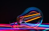 a colorful light bulb with a black background