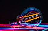 a colorful light bulb with a black background
