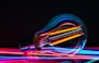 a colorful light bulb with a black background