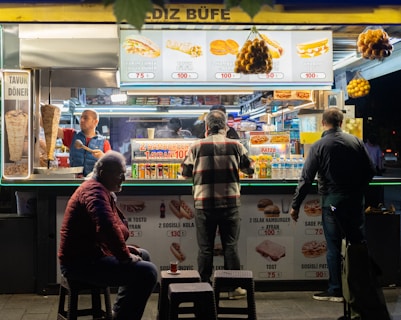 a group of people standing in front of a food stand
