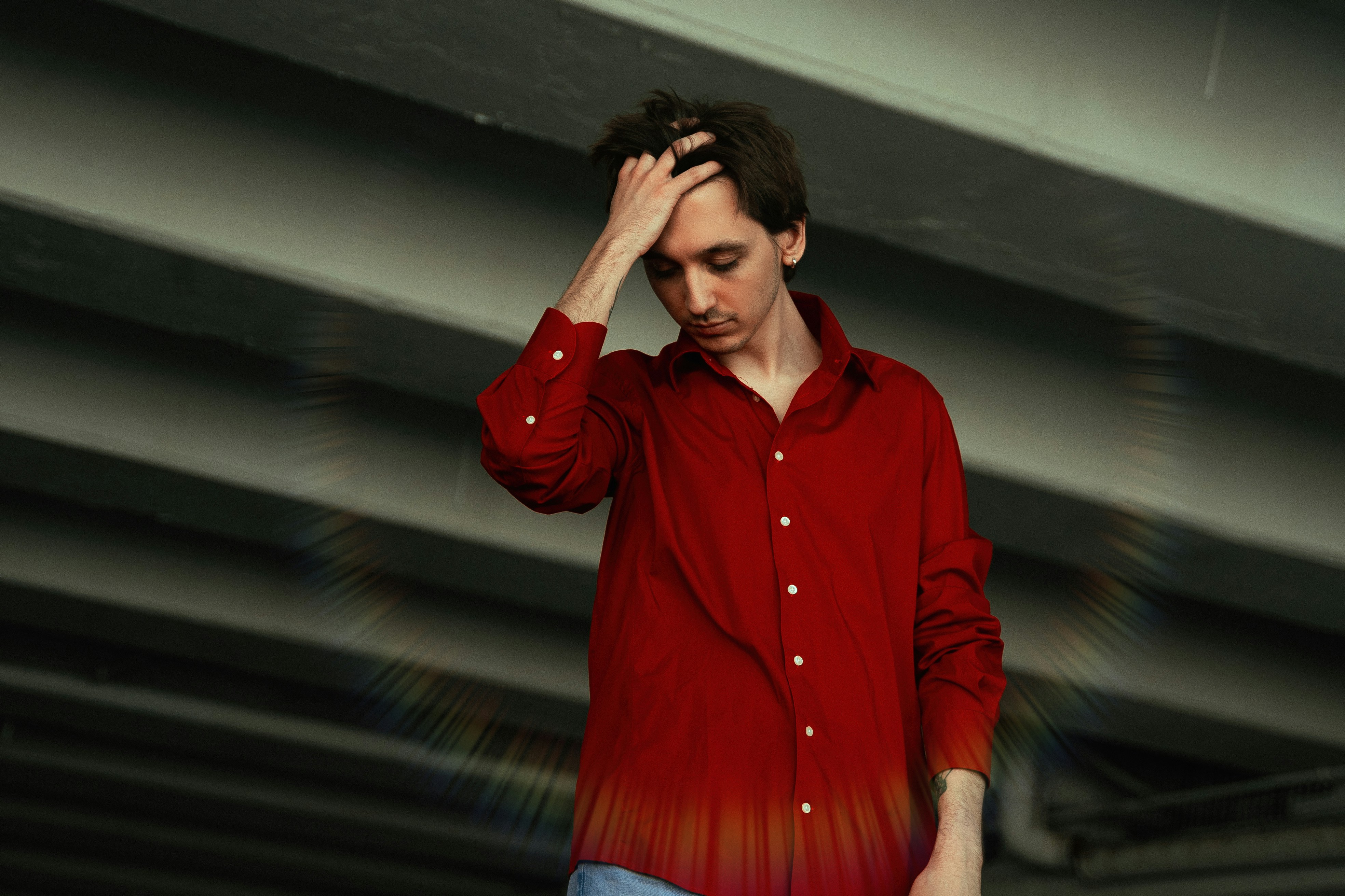 a man in a red shirt is holding his head