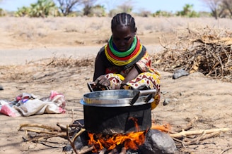 a woman cooking food over an open fire