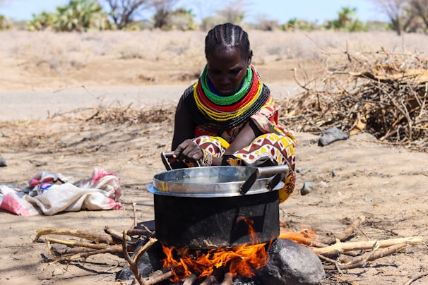 a woman cooking food over an open fire