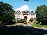 a house with a driveway and trees in front of it