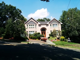 a house with a driveway and trees in front of it