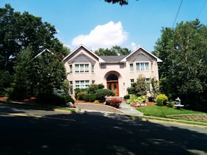 a house with a driveway and trees in front of it