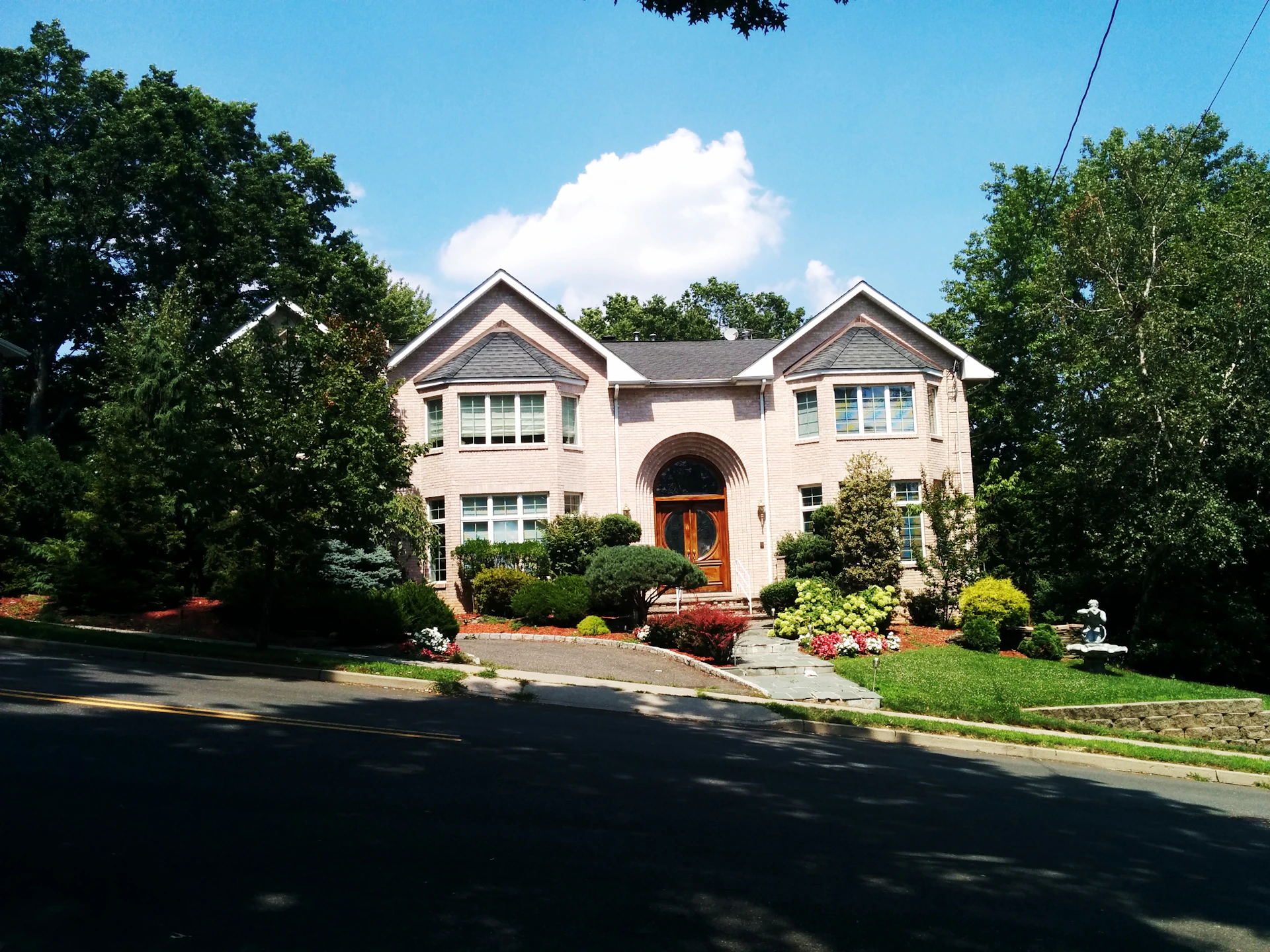 a house with a driveway and trees in front of it