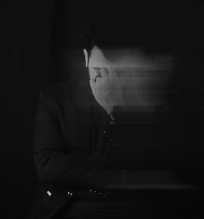 a man in a dark room with his head turned to the side