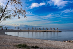 a body of water sitting next to a sandy beach
