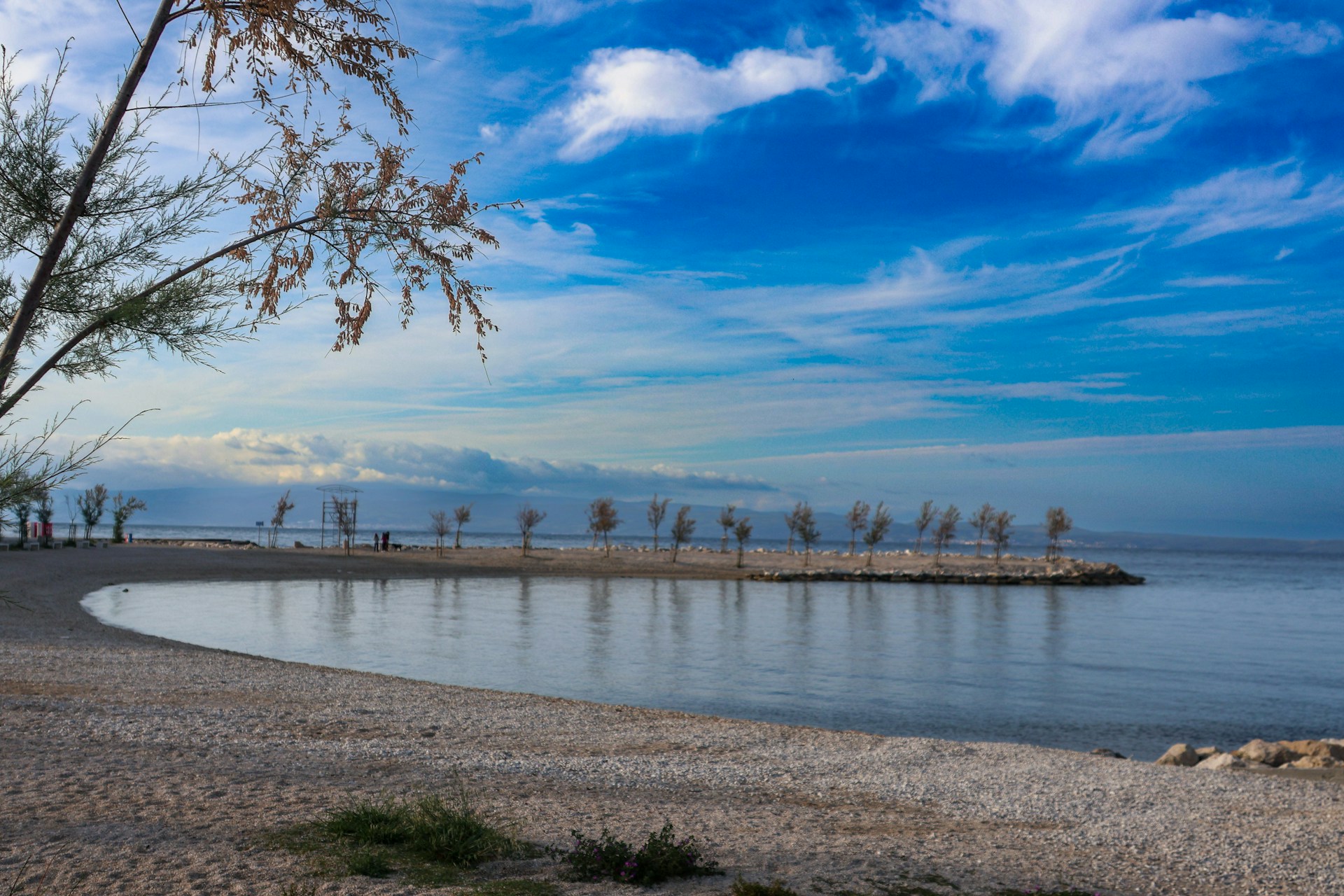 a body of water sitting next to a sandy beach