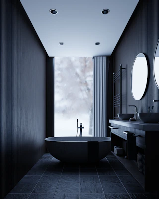 Modern dark bathroom with freestanding tub and double vanity.
