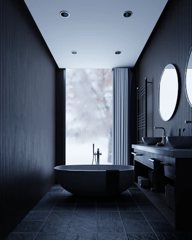 Modern dark bathroom with freestanding tub and double vanity.